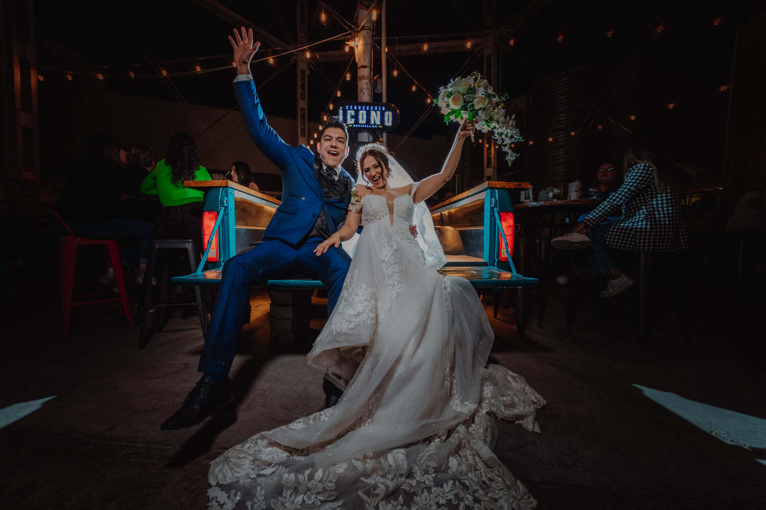 Ein frisch verheiratetes Paar, das in Mexiko bei ihrer Hochzeit die Hände zur Feier erhebt.